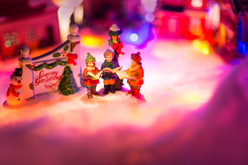 Miniature figurine in a winter landscape of Christmas time. Selective focus to reserved spaces for text for message to add on.