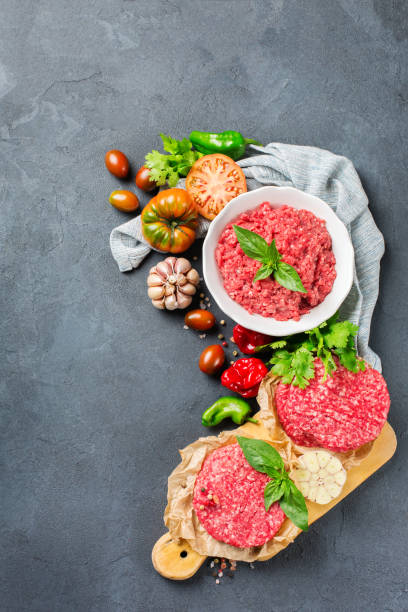 Homemade raw organic minced beef meat burger cutlet and vegetables