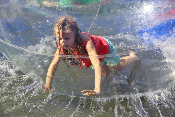 Group of children running into clear lake water