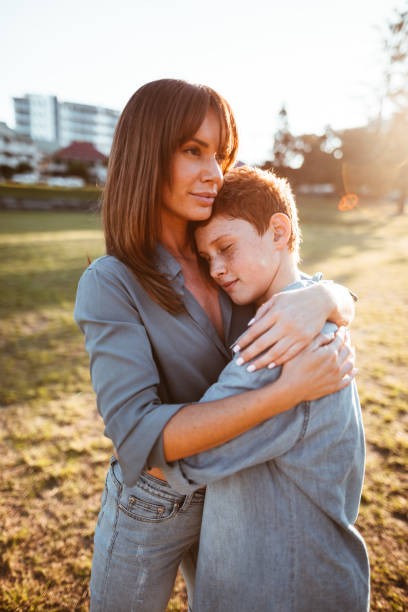 istock teenager embraced with mom consoling her son 874176018