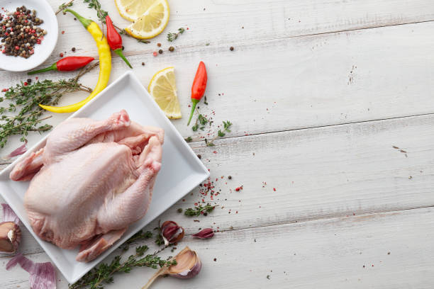 istock Raw chicken, herbs and spices on white wooden background 874176038