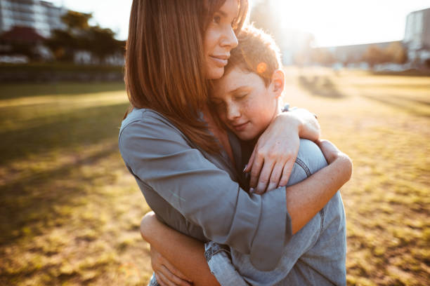 teenager embraced with mom consoling her son
