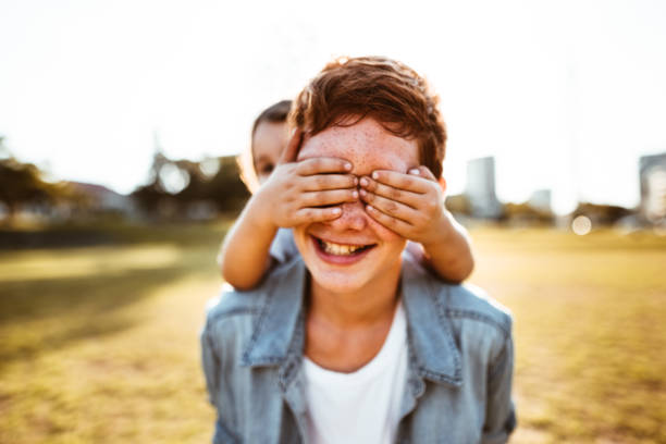 istock two lovely kids piggyback at the park 874176272
