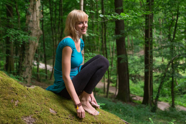 istock Young woman practicing yoga in forest. 874180442