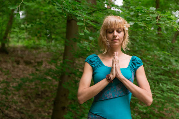 istock Young woman practicing yoga in forest. 874182988