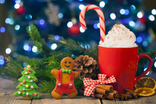 istock Christmas cappuccino and gingerbread cookies infront Christmas tree on Rustic Wooden Table 874183538