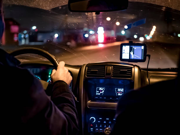 istock man, driving a car at night 874186636