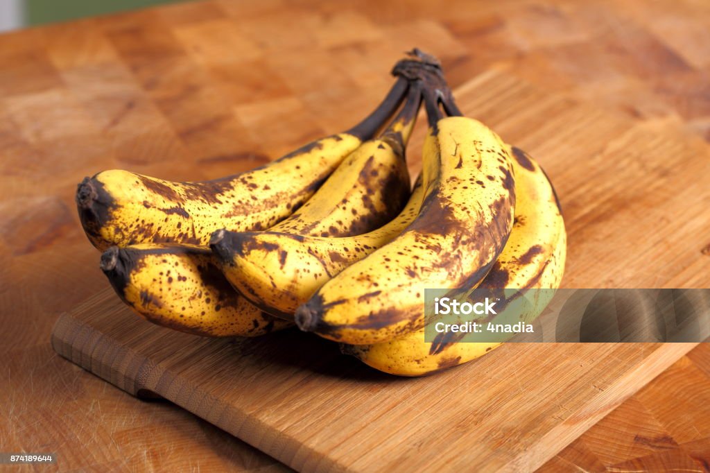 Bunch of overripe bananas on a wooden background Banana Stock Photo