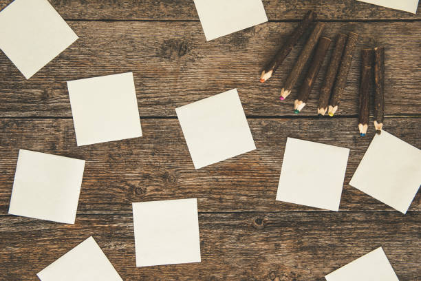 istock White paper stickers, colored pencils on wooden table 874190212