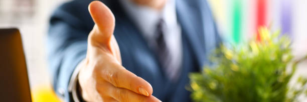 istock Man in suit and tie give hand as hello in office 874190504