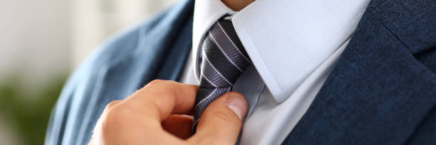istock Male arm in blue suit set tie closeup 874190528