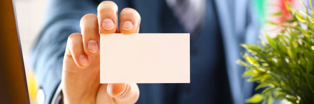 istock Male arm in suit give blank calling card 874190544