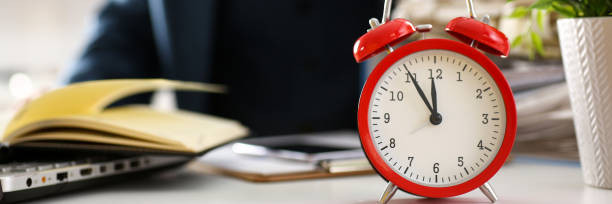 istock Red alarm clock shows late time closeup 874190566