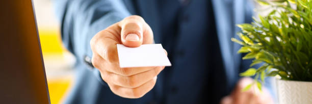 istock Male arm in suit give blank calling card 874190572