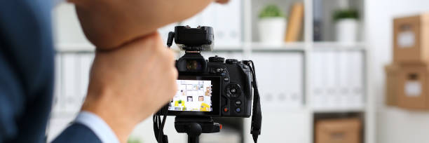 istock Male arms in suit mount camcorder to tripod 874190612