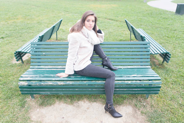 Outdoors portrait of a fashion girl sitting on a bench.
