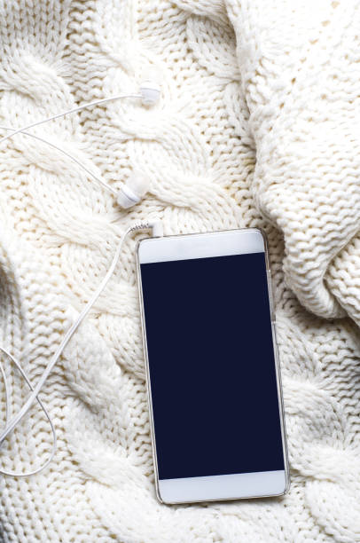 istock Smartphone and headphones over a white sweater 874203870