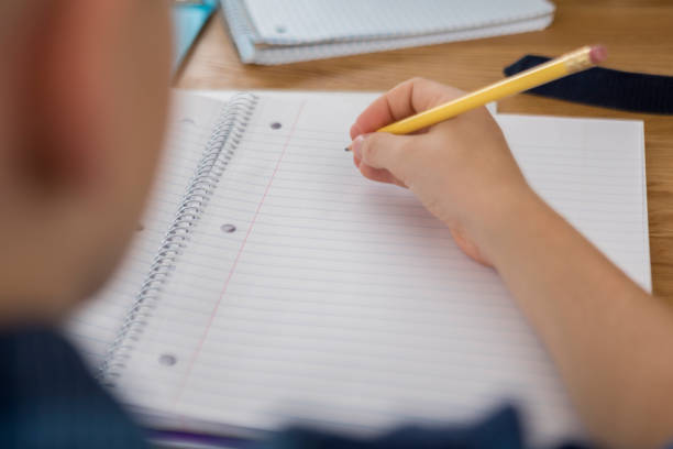 istock Unrecognizable preteen boy prepares to write on a blank page 874205280