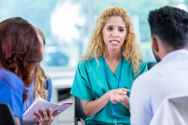 istock Serious nurse discusses an issue with colleagues 874205320