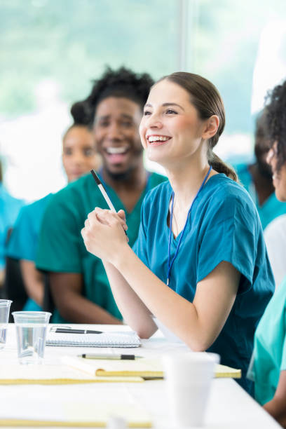 smiling attentive healthcare professional during medical seminar - lecture hall university student seminar imagens e fotografias de stock