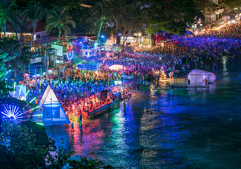 The famous outdoor Full Moon Party at the public Haad Rin Beach on the Island Koh Phangan in South Thailand. Nikon D810. Converted from RAW. (Note: All logos or copyrighted elements have been removed or altered. Unrecognizable people.)