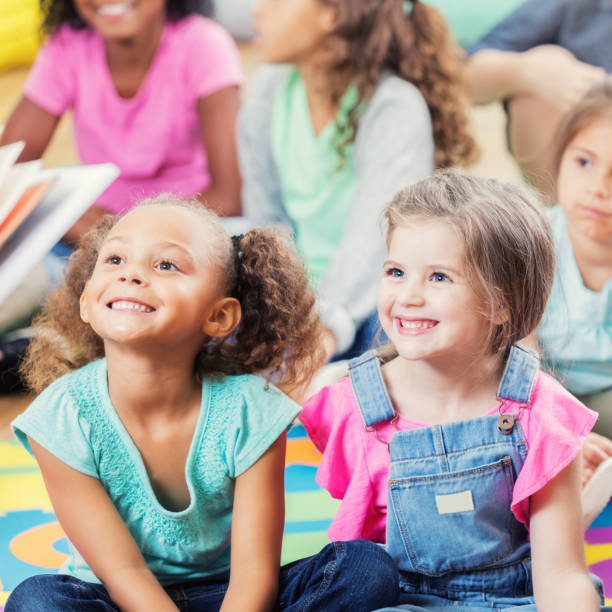 istock Adorable kindergarten students listen during story time 874205676