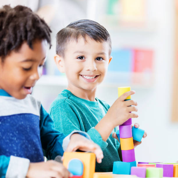 istock Playful kindergarten student plays with building blocks 874205682