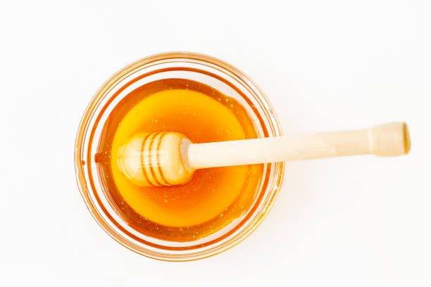 istock Dipper Lying in Bowl with Pure Honey 874218350
