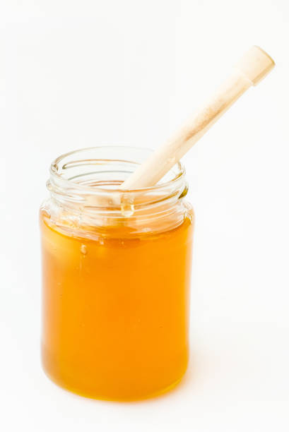 istock Dipper Lying in Jar with Delicious Honey 874218354