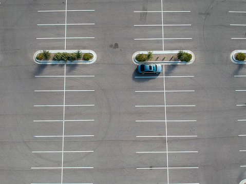 Several cars are parked in a large parking lot.