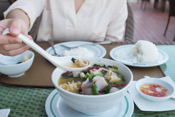 istock asia girl using spoon eating thai food 874228462