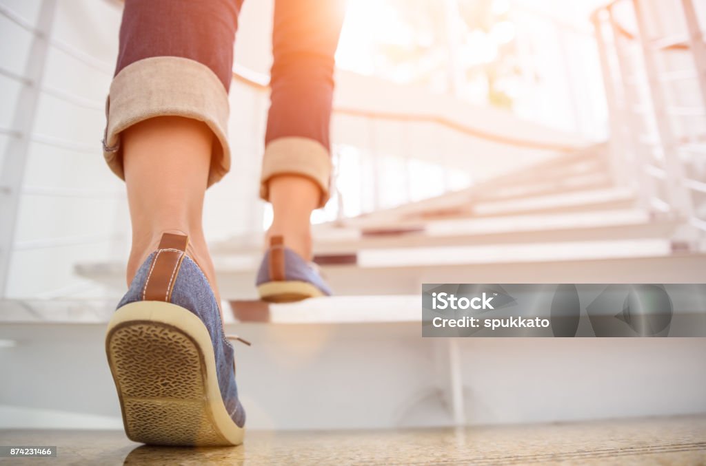 Adulto joven subiendo las escaleras con el fondo de deporte de sol. - Foto de stock de Escaleras libre de derechos