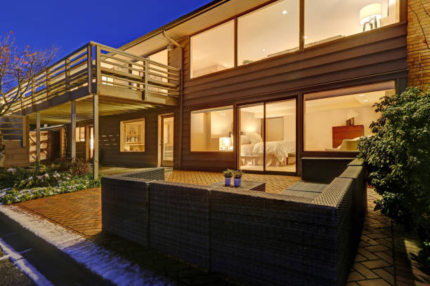 istock Sunset view of two story home with upper deck and lower poolside patio 874244334