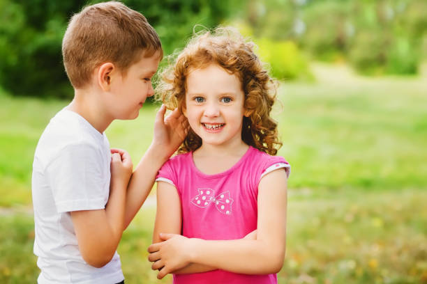 istock Little boy and girl whispers. 874250774