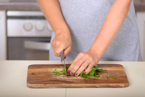istock Woman cutting parsley with a knife 874257440