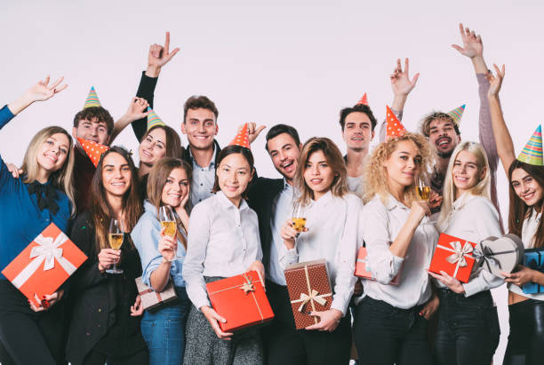istock Group of happy young people with gift boxes. 874258174