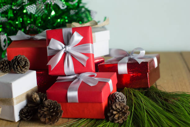 istock Red and white gift box on wood table with pine tree and pine cone background. Christmas, New year, Valentine or Birthday concept. Still life. 874258246