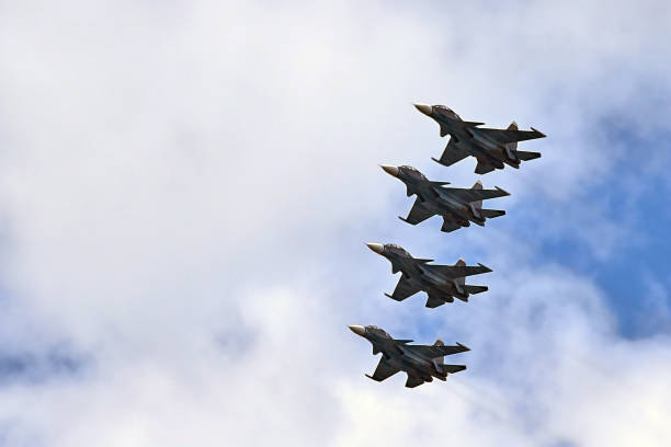 istock four fighters jet flying in formation against a blue sky 874267586