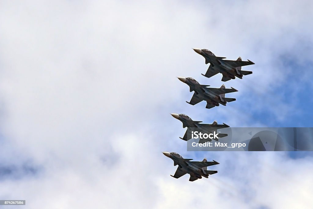 four fighters jet flying in formation against a blue sky Airplane Stock Photo