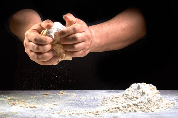istock hef hand knead the dough.home cooking. Horizontal photo with text area space. Black background 874267834