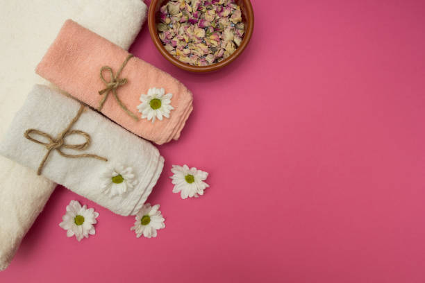 istock Concept spa procedure with dried flowers and towels, pink background. 874270748