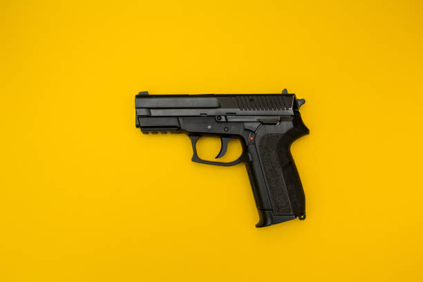 istock Pistol on a yellow background. 874271444