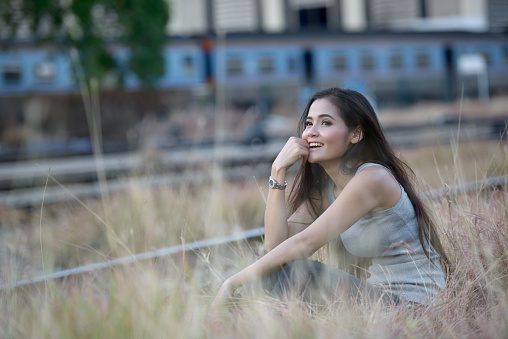 Portrait of Young beautiful Asian woman getting away from it all at Hua Lamphong Bangkok railway station