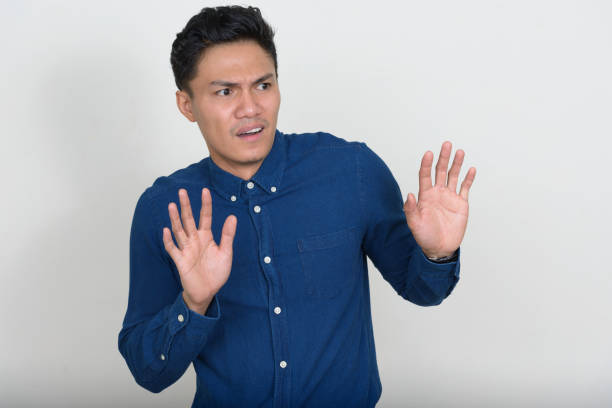 istock Young Asian businessman wearing blue button down shirt against white background 874285472