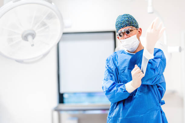 istock plastic surgeon wearing scrubs and protective rubber gloves in operating room 874285666