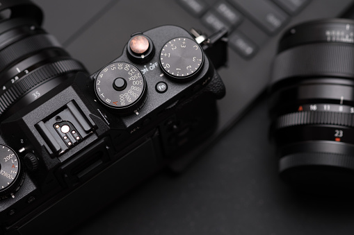 Digital DSLR camera in a young woman's hand against a white background with copy space