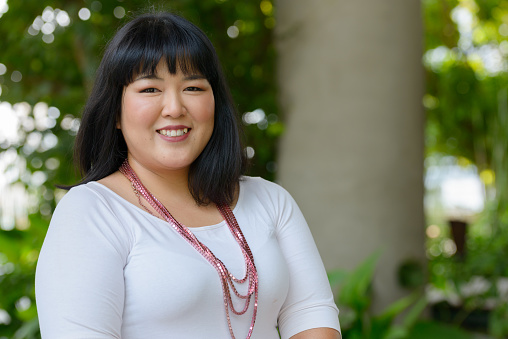 Portrait of beautiful overweight Asian woman getting away from it all with nature