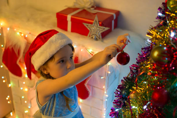 istock Cute little girl decorates Christmas tree 874290276