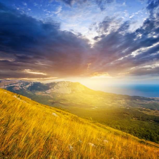 istock dramatic sunset over a mountain  slope covered by a dry grass 874297462