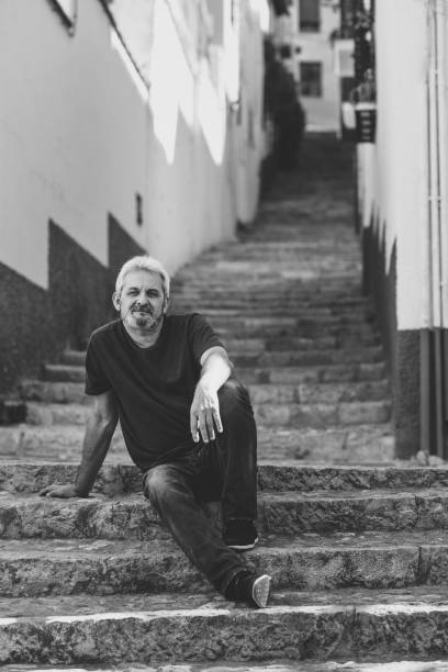 istock Mature man sitting on steps in urban background 874297610